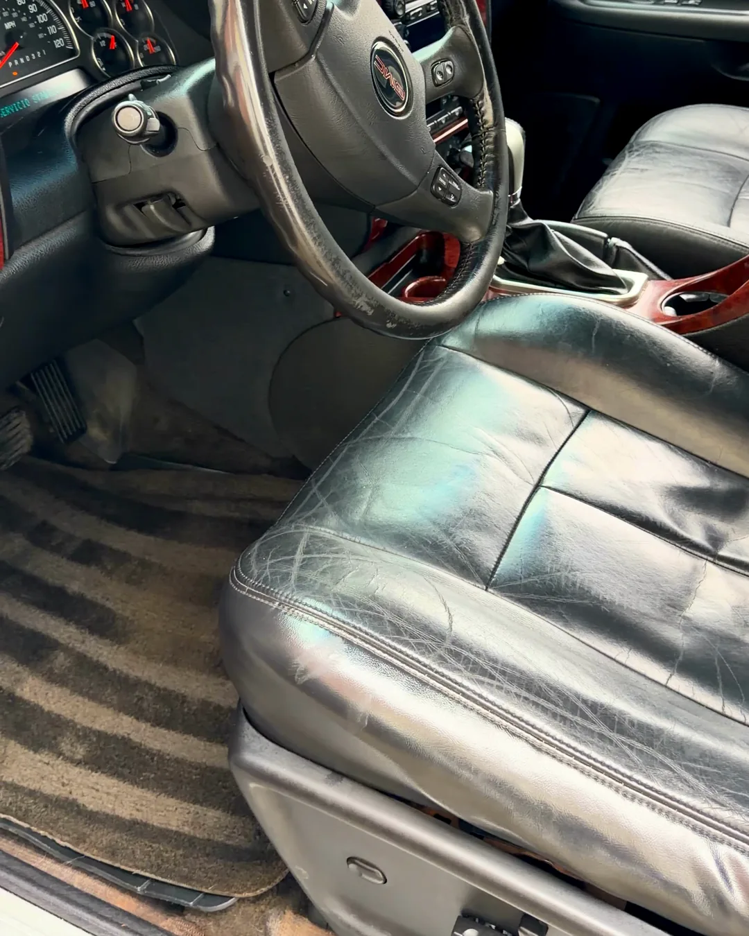 Lado del chofer de la GMC con alfombra negra limpia y asiento de piel con brillo después del detallado