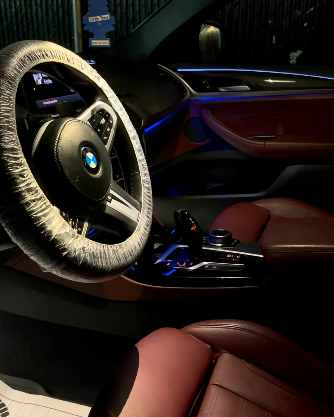 Interior de BMW de noche con luces ambientales después del detallado