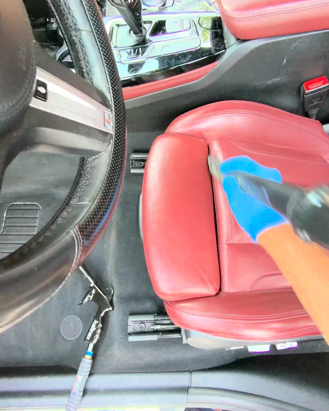 Limpieza de asiento de piel roja con guantes